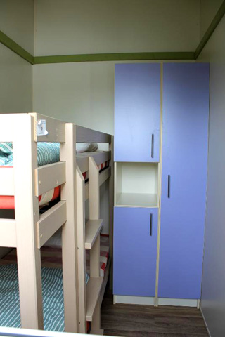 Une chambre avec lits superposés et rangements